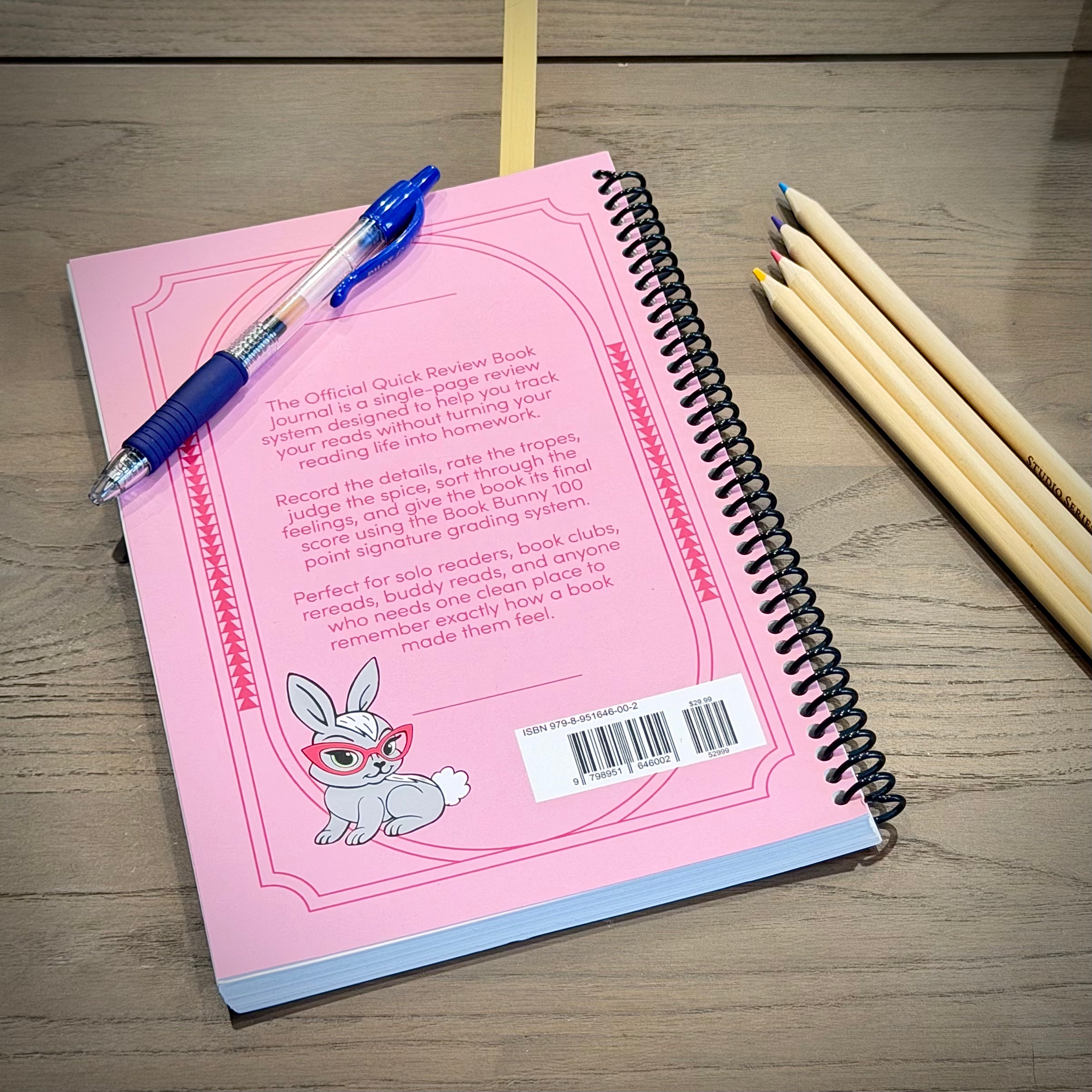 Back cover of the pink Book Bunny™ Official Quick Review Book Journal, showing the product description, Book Bunny illustration, ISBN barcode, and coil binding.