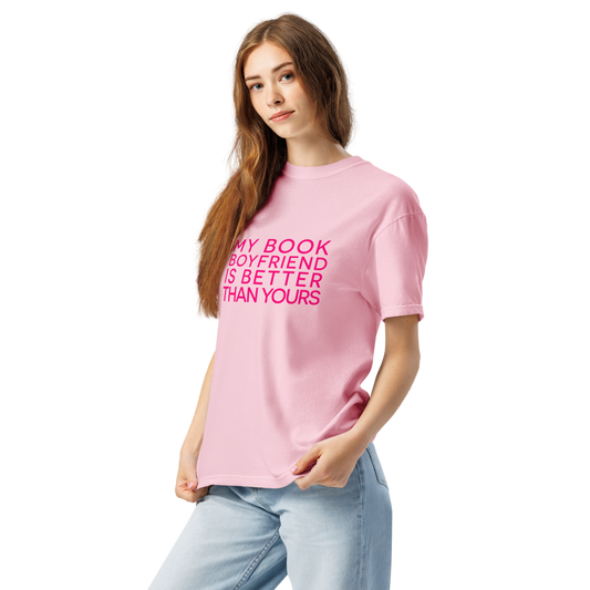 A woman wearing a light pink crewneck t-shirt with the text 'My Book Boyfriend is Better than yours' printed in bright pink across the chest, paired with light blue jeans, set against a plain white background.